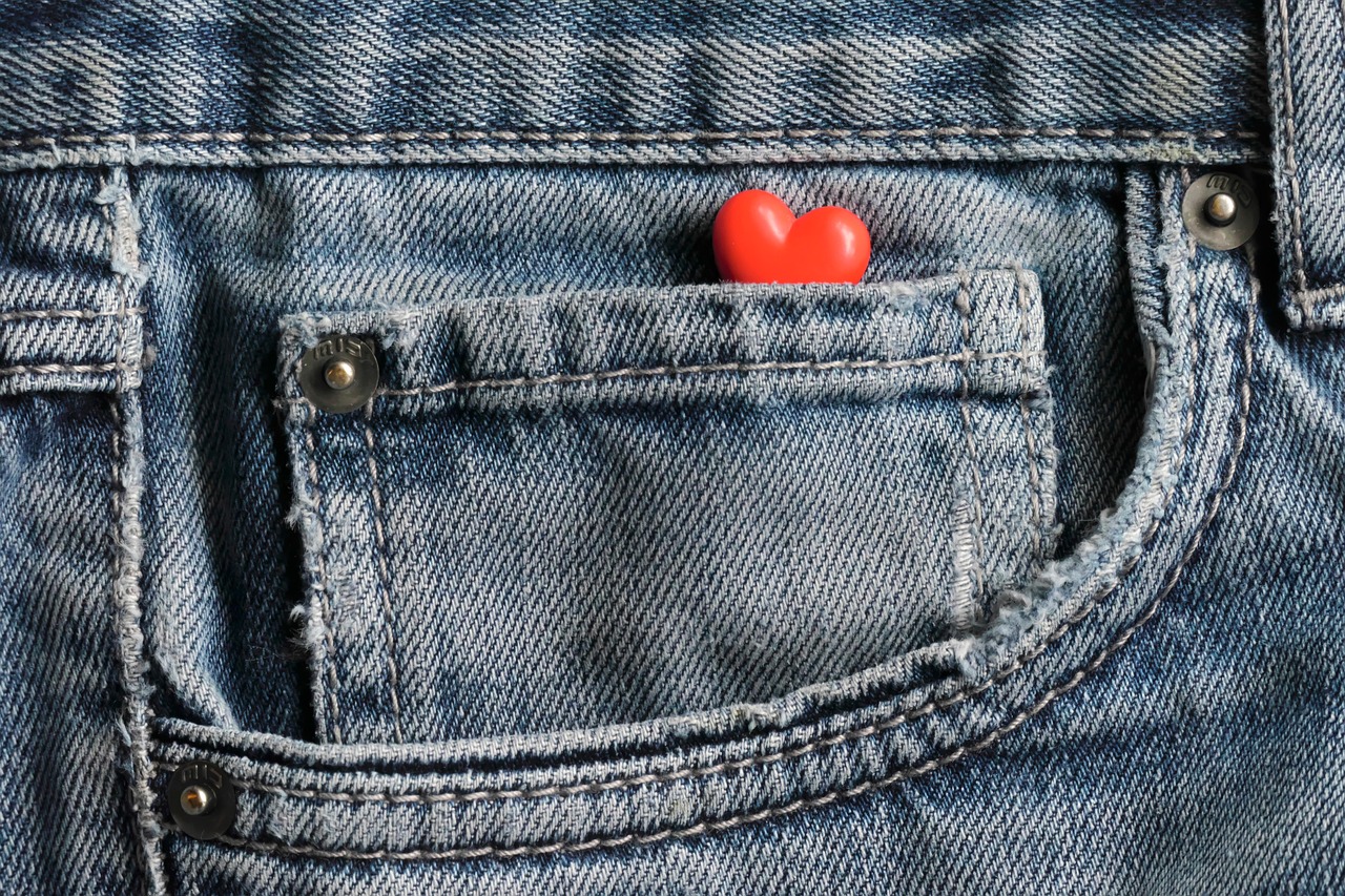 Close-up of a shopper examining the inner seam stitching and interior tag of a denim garment.