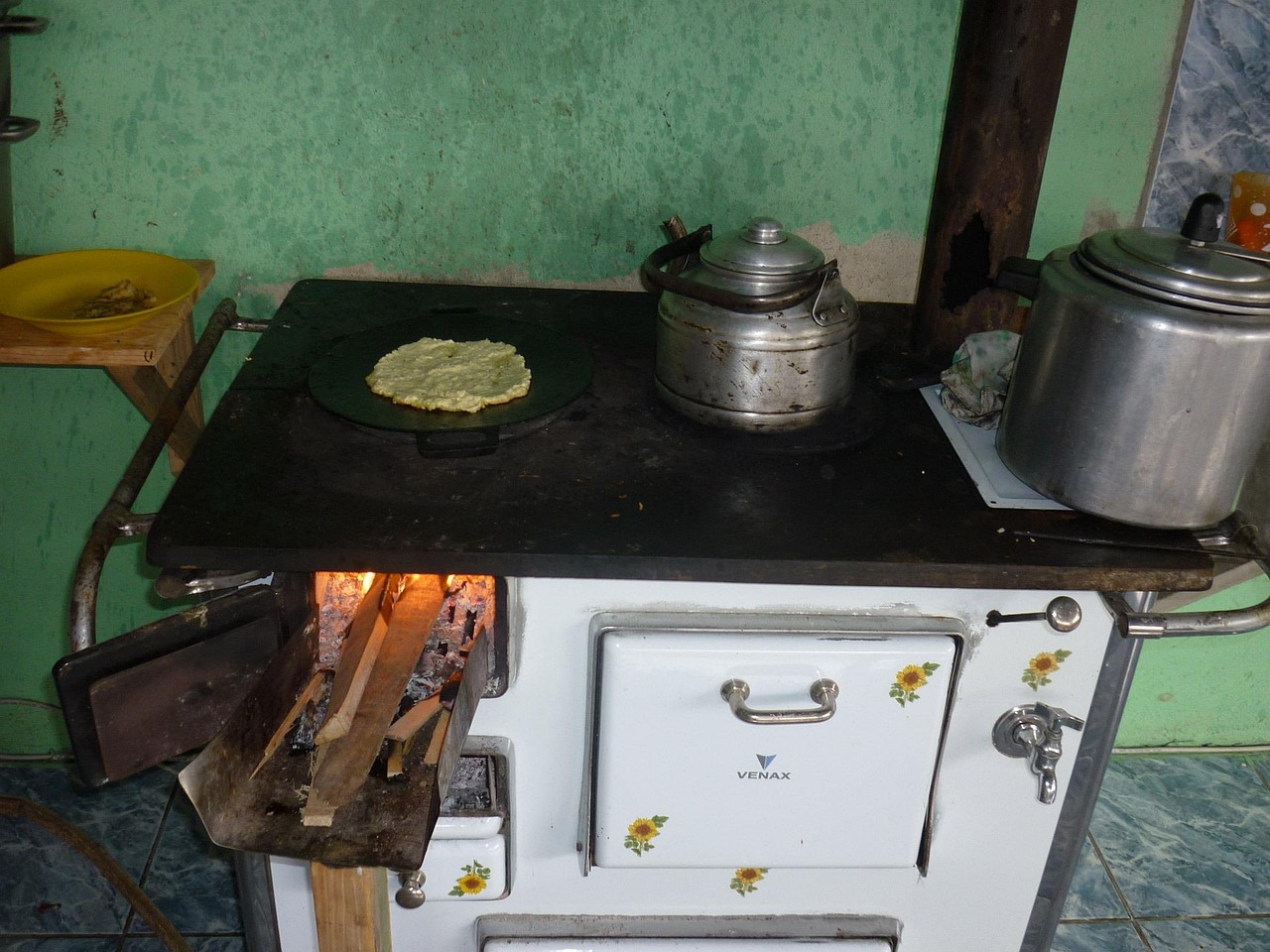 A modern high-efficiency wood stove burning cleanly inside a residential living space.