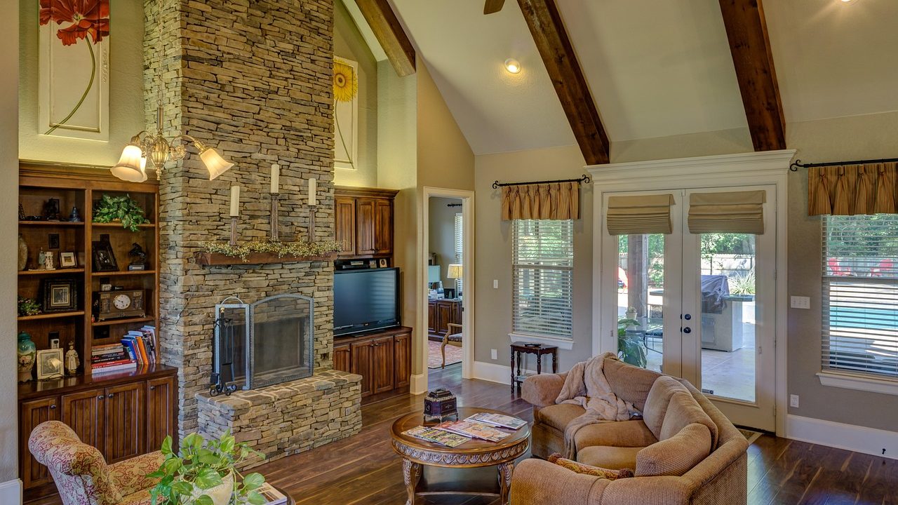 A living room featuring an aging masonry fireplace insert set in a brick wall.