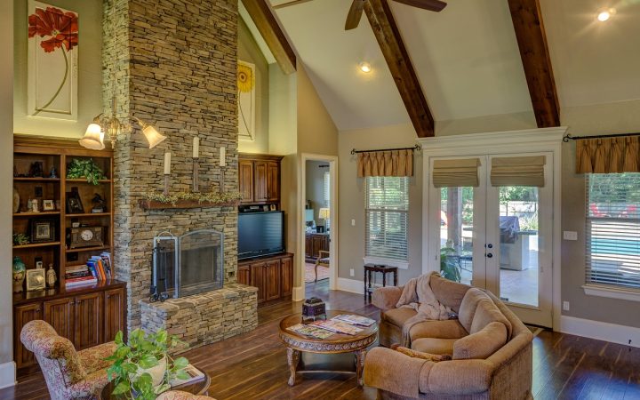 A living room featuring an aging masonry fireplace insert set in a brick wall.