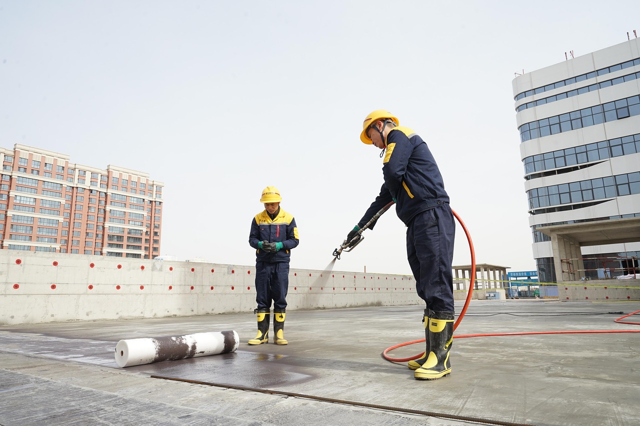 Exterior rubberized waterproofing membrane with dimpled drainage board attached to a concrete wall