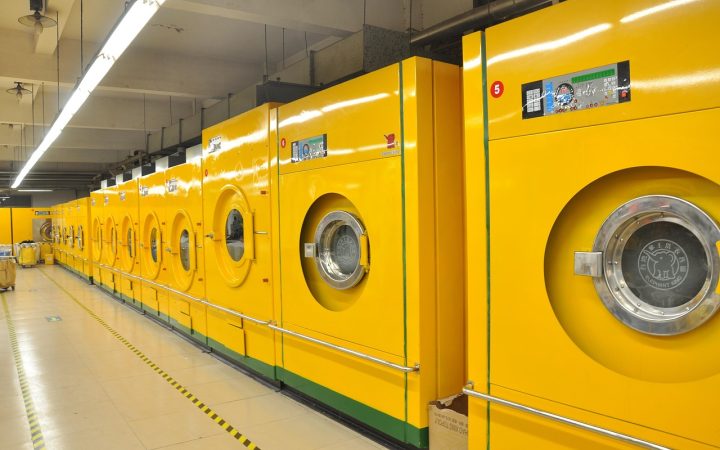 Side-by-side front load and top load washing machines in a well-lit modern American laundry room.
