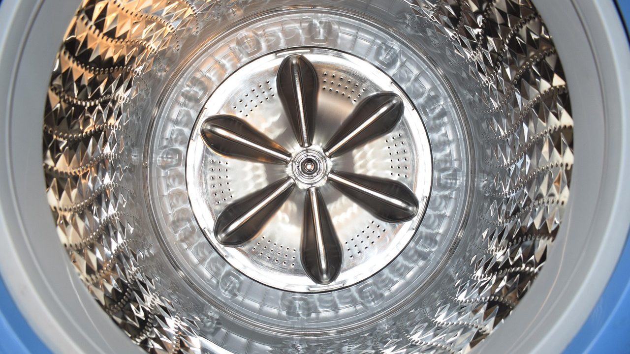Clean front-load washing machine door rubber gasket in a bright modern home laundry room.