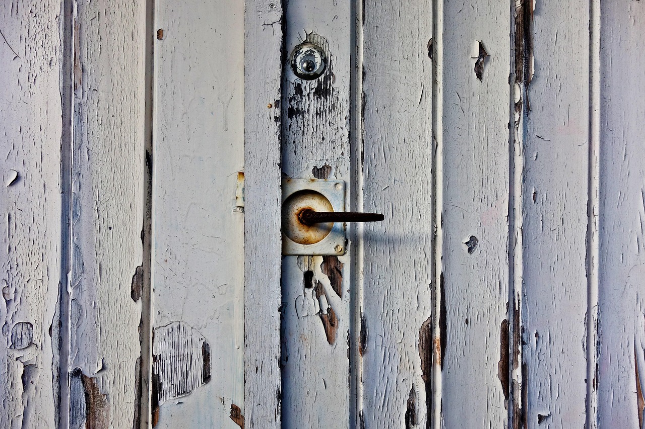 Technician using specialized winding bars to adjust garage door torsion spring tension.