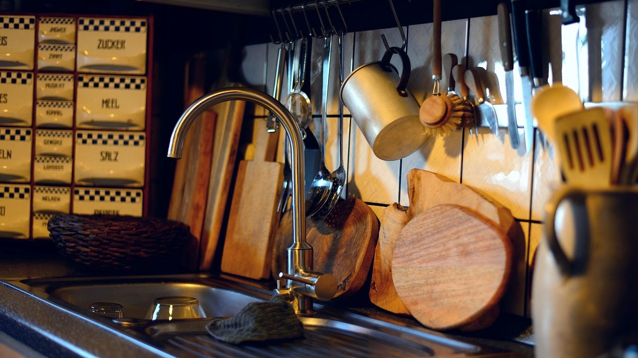 Plumber installing a new garbage disposal under a kitchen sink