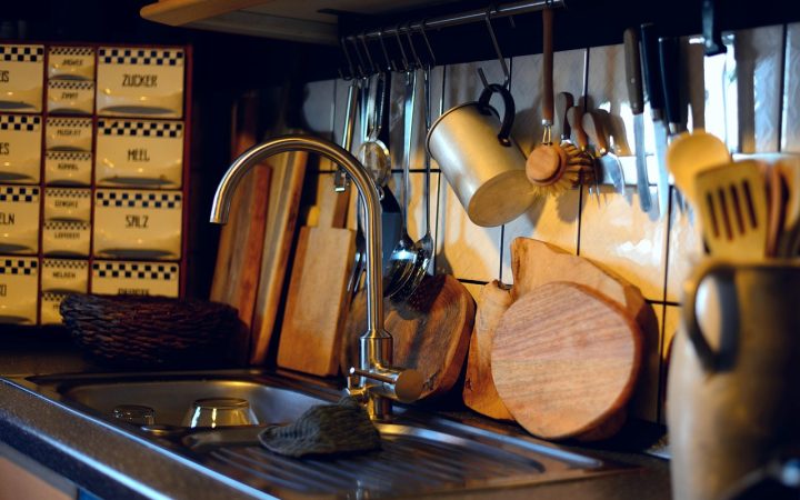 Plumber installing a new garbage disposal under a kitchen sink