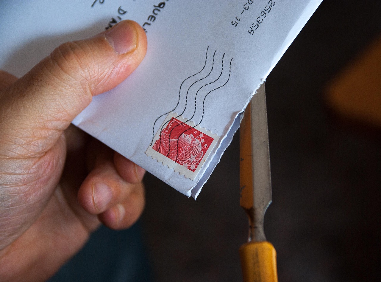 A person preparing a formal cancellation letter in a certified mail envelope with a USPS return receipt.