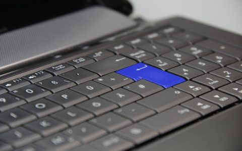 A hardware security key inserted into a USB-C port on a developer laptop in a remote workspace.