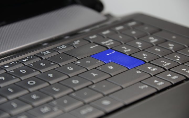 A hardware security key inserted into a USB-C port on a developer laptop in a remote workspace.
