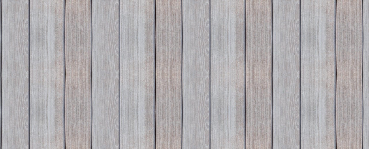 Technician rolling clear polyurethane finish onto freshly sanded hardwood floors.