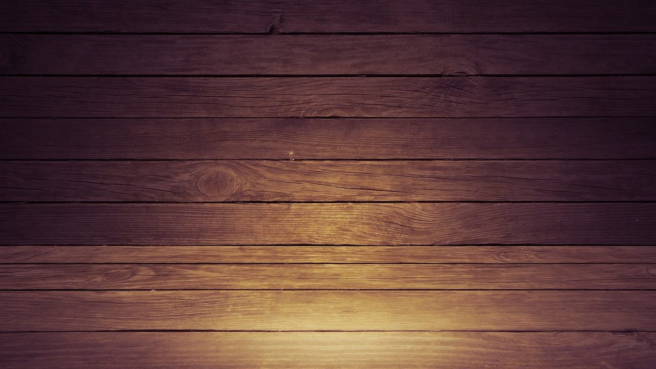 Contractor installing wooden floorboards in a residential living room