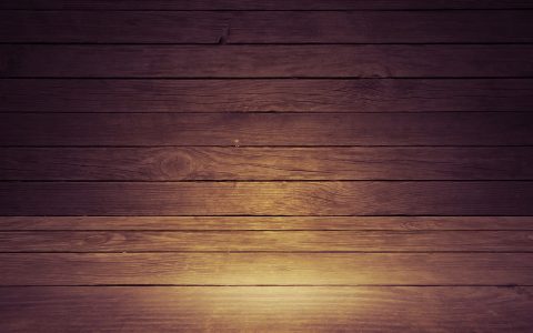 Contractor installing wooden floorboards in a residential living room
