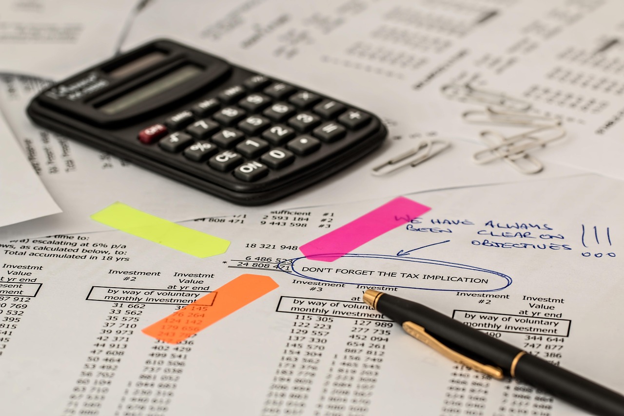 Financial documents and insurance comparison paperwork organized on a home office desk.