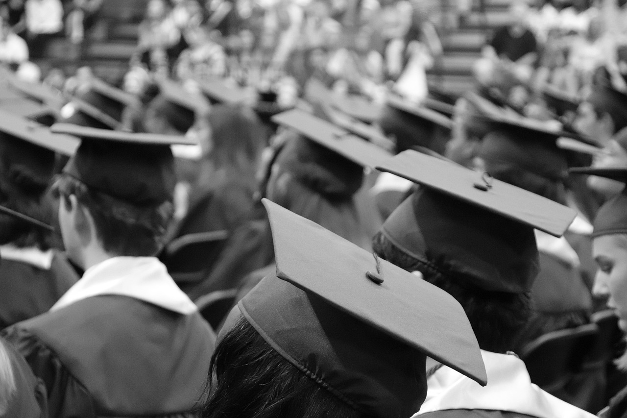 High school senior holding a graduation cap and diploma folder