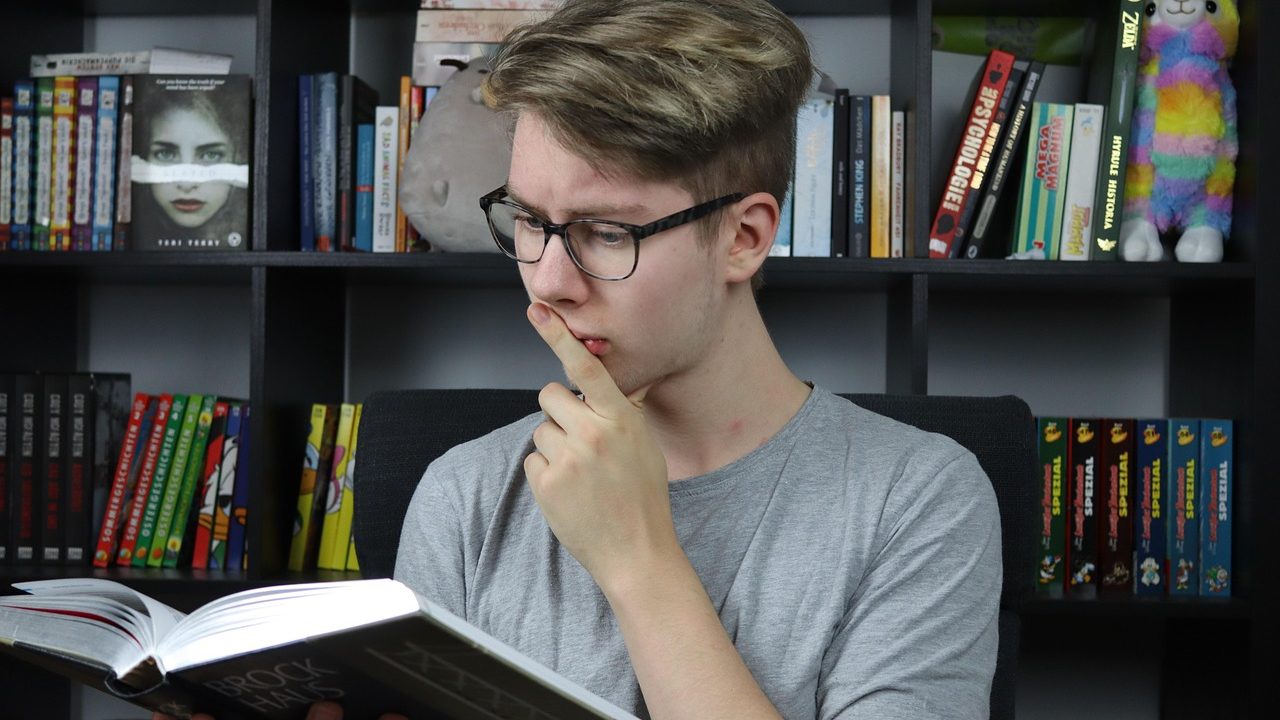 High school student reviewing notes and textbooks at a desk