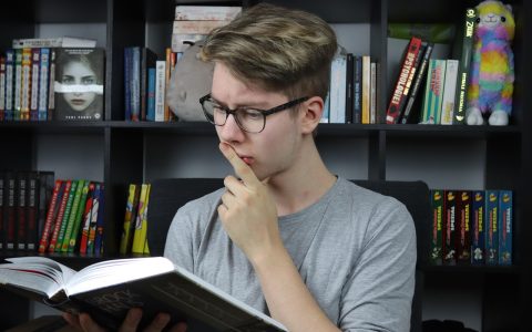 High school student reviewing notes and textbooks at a desk