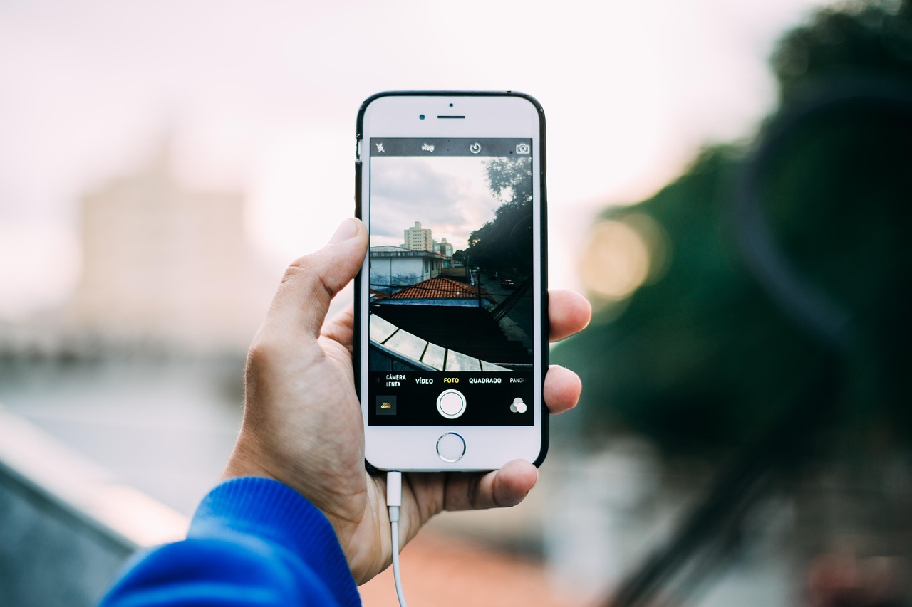 A person photographing a textbook cover with a mobile phone for documentation.