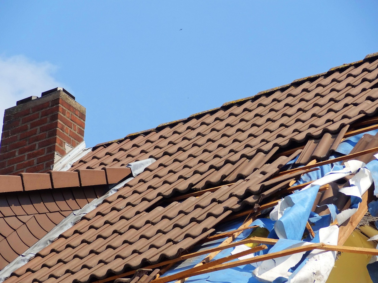Damaged roof shingles on a residential home after a major storm