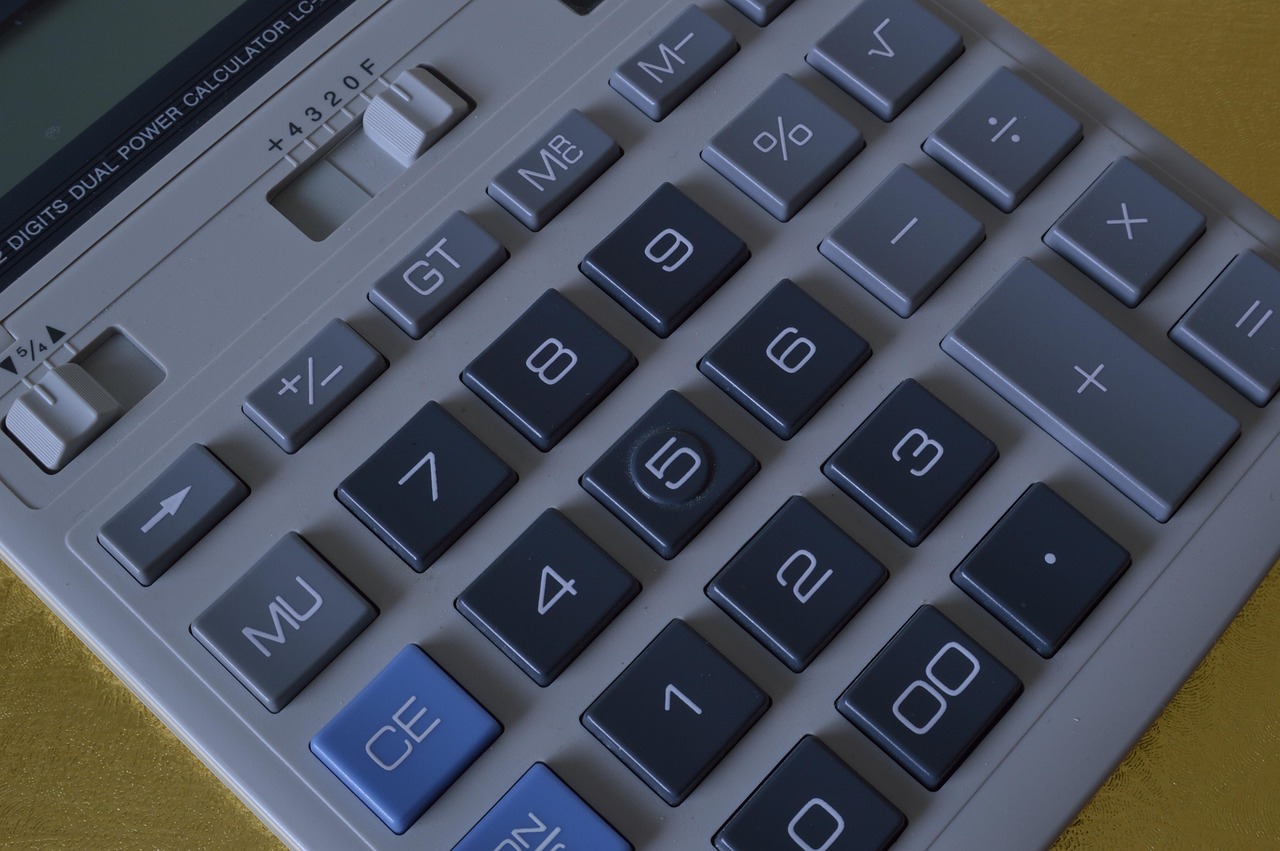 A homeowner calculating expenses using a calculator and notepad