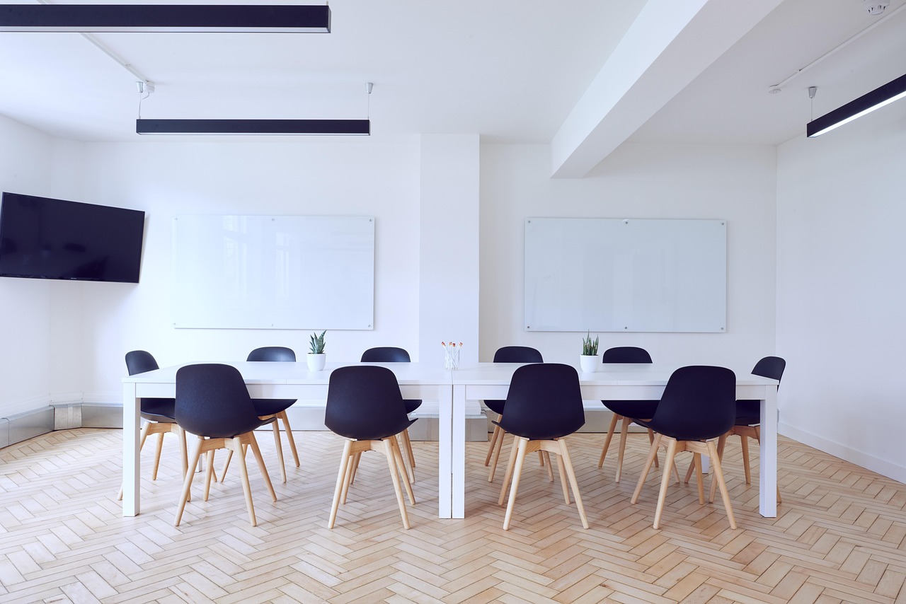 Two colleagues discussing a proposal across a meeting room table