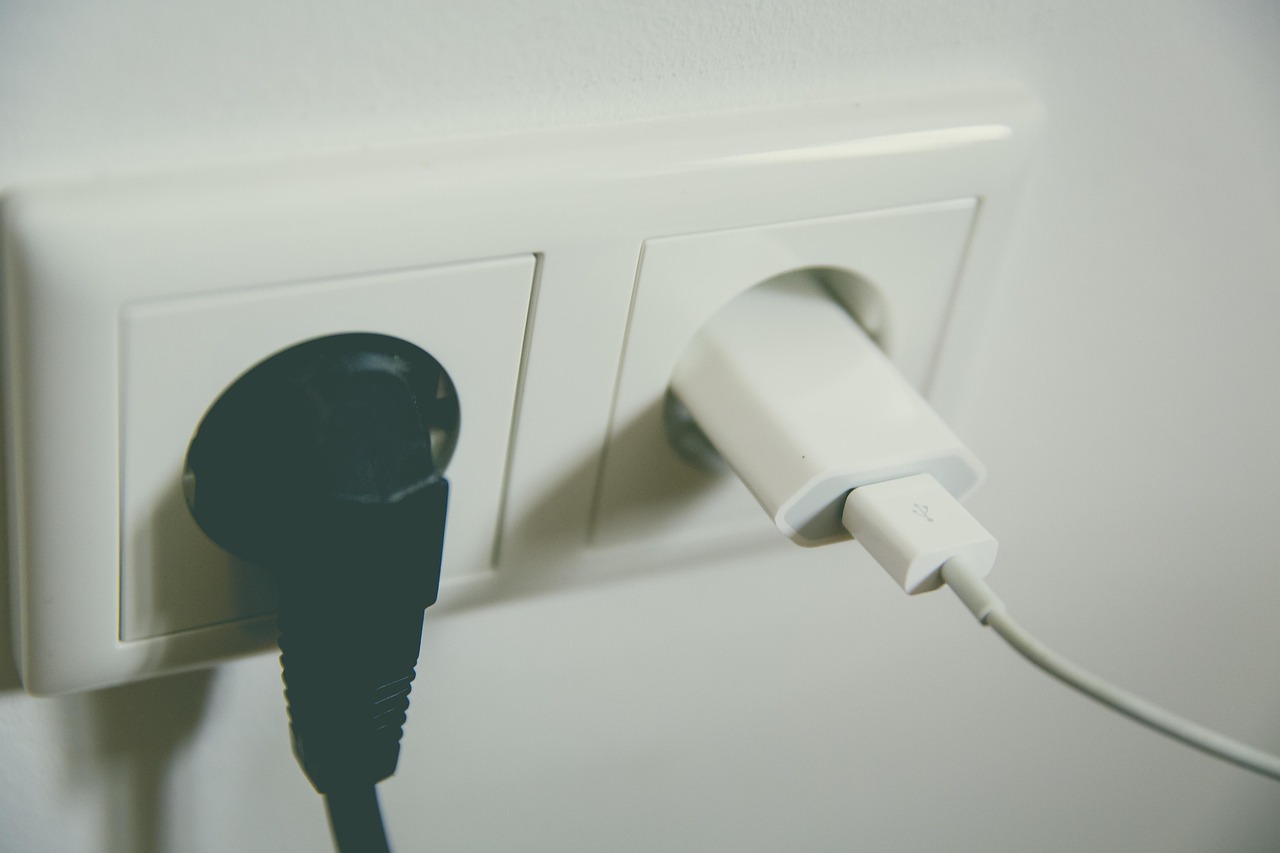 A plug-in energy monitor connected to a wall outlet measuring an appliance power draw.
