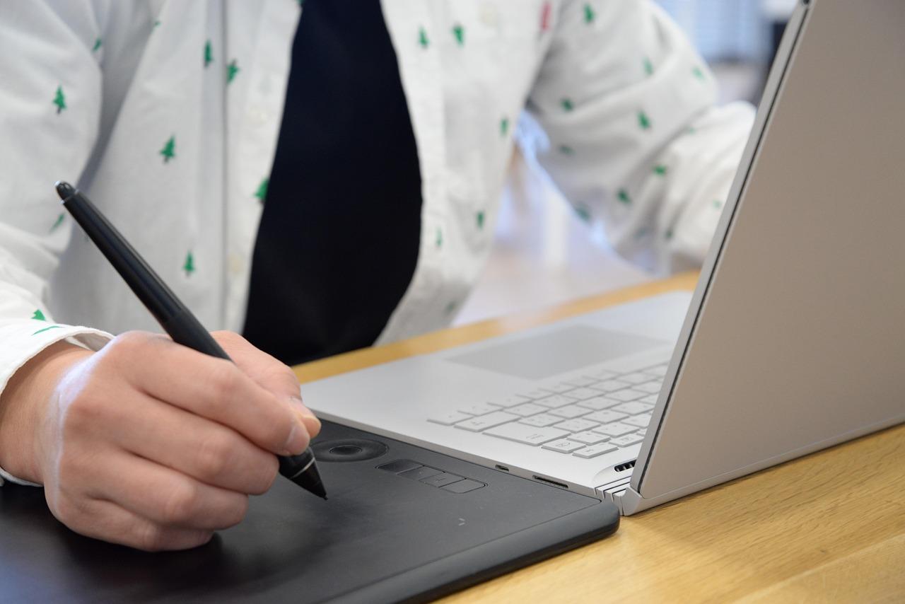 A designer sketching user journey notes on a digital tablet next to coffee.