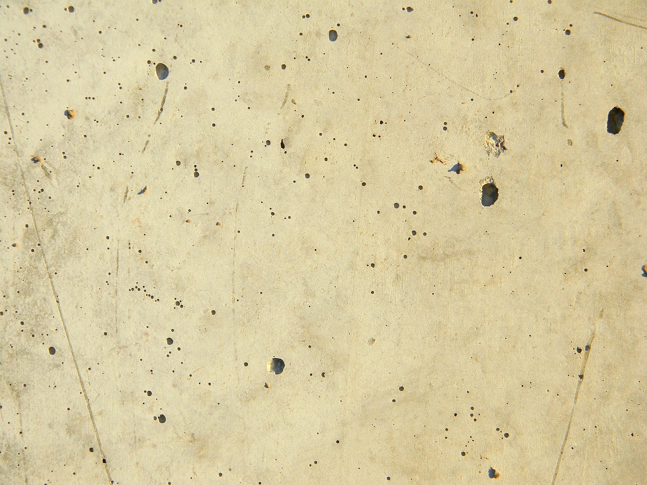 Applying a chemical degreaser to an oil stain on a concrete patio.