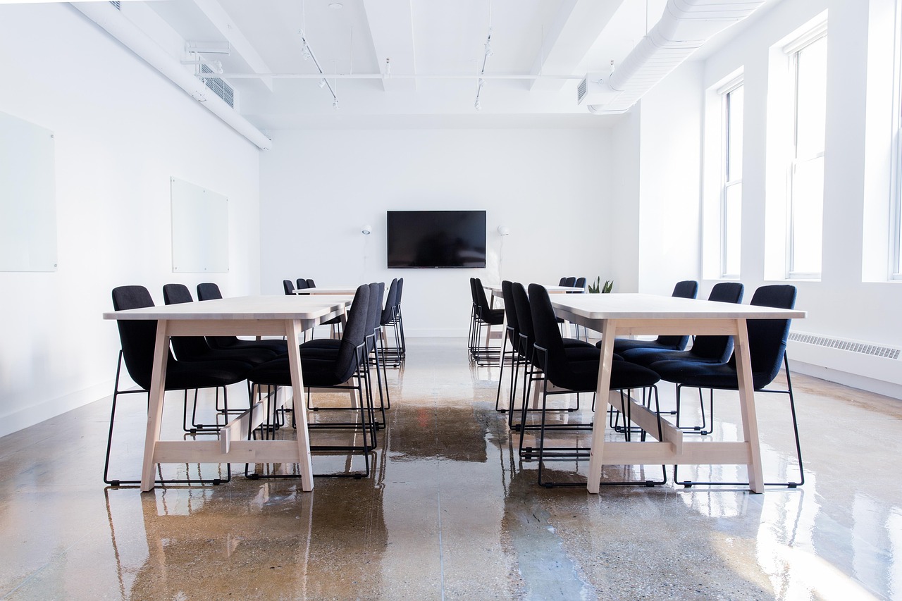 Two professionals sitting at a conference table discussing a project plan during a one-on-one meeting.