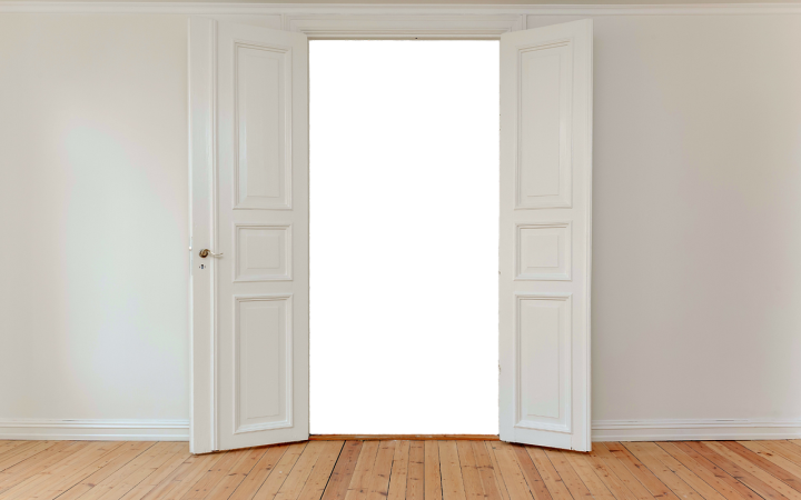 DIY homeowner tapping a pin out of a door hinge with a punch and hammer