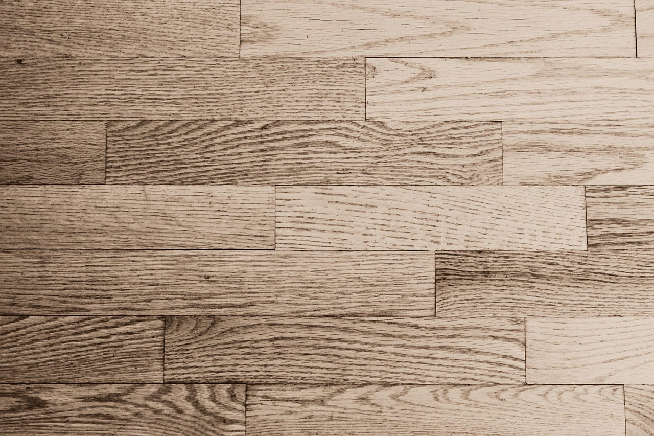 Cross-section illustration concept of floor joists beneath subfloor and hardwood planks.