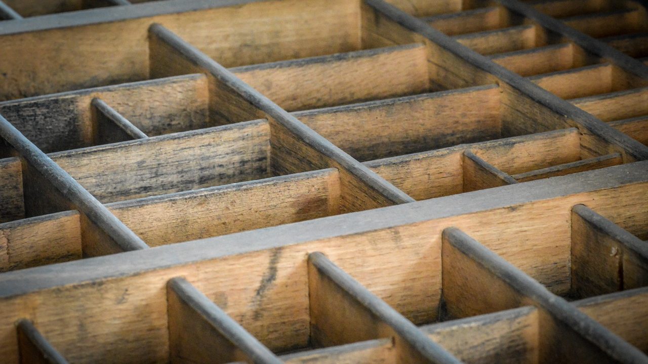 Close-up of hands repairing a wooden cabinet drawer