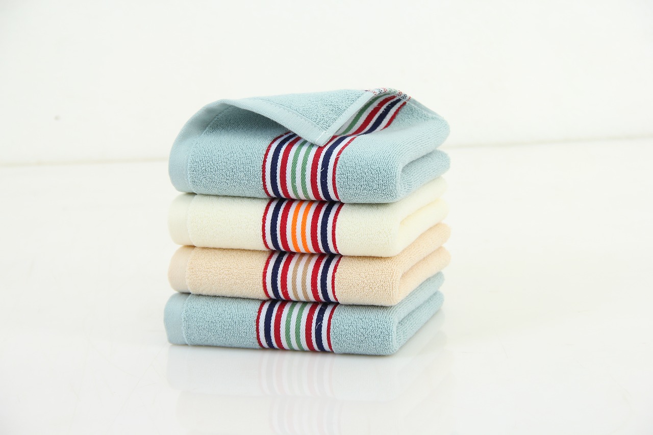 A person using a soft cloth towel to swap scent gently from a pet's face.