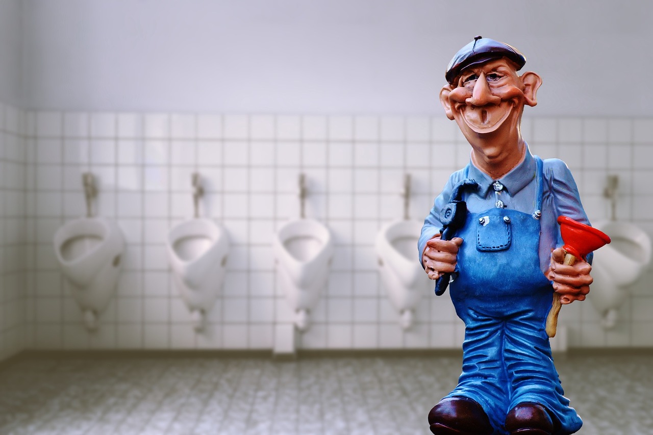 A plumber inspecting the internal flush mechanism inside a opened porcelain toilet tank.