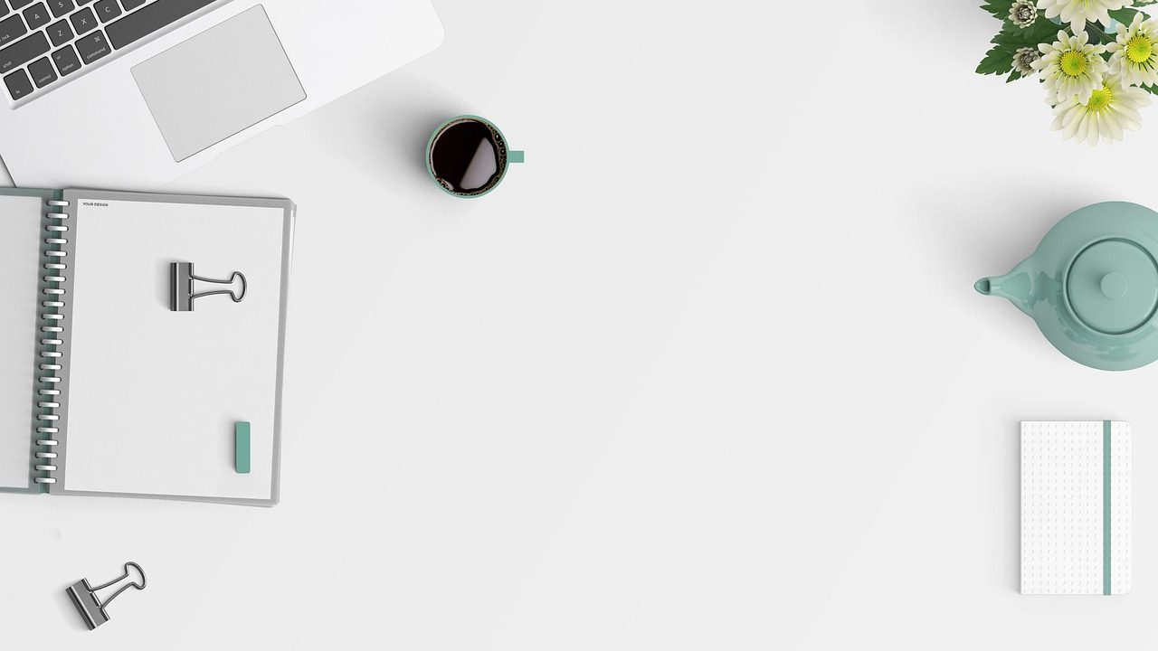 A clean, organized desk workspace with a laptop and notebook representing digital order.