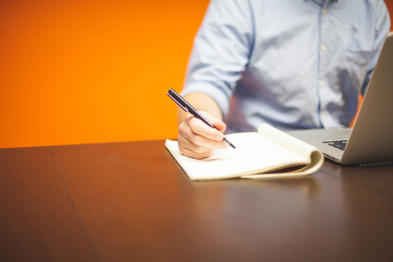 A corporate employee reviewing internal transfer documentation on a modern desk setup.