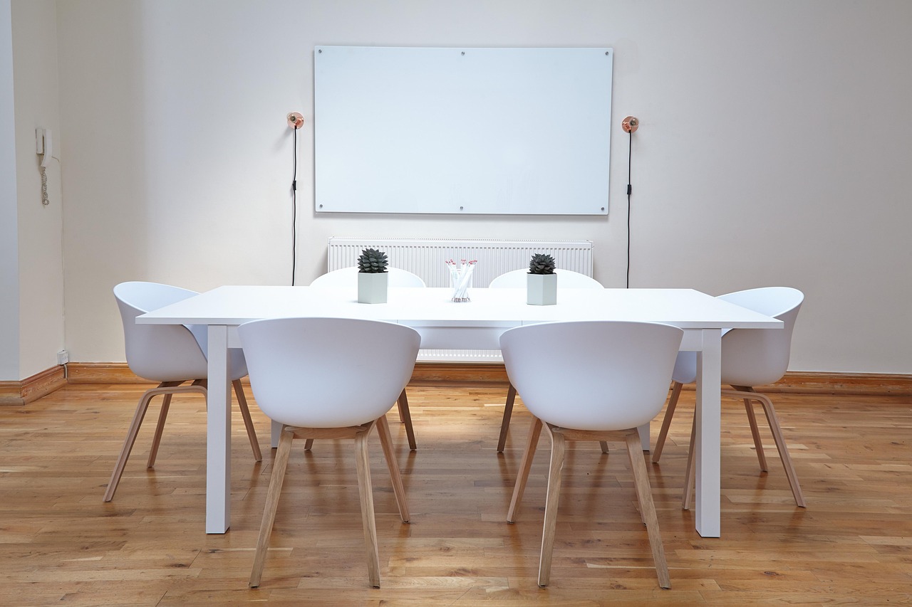 A software team discussing product features around a glass whiteboard.