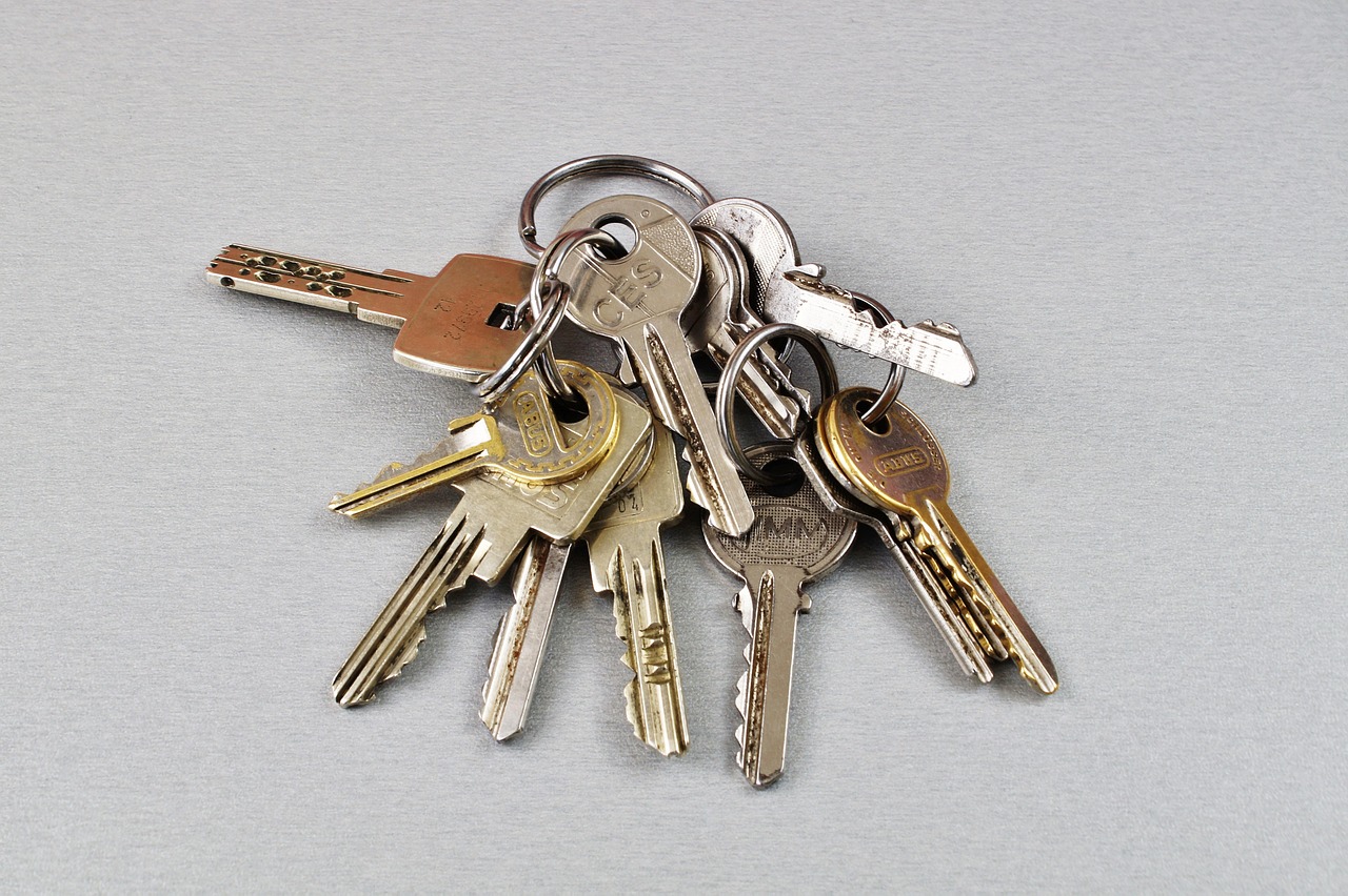 Close-up of property deed documents and house key on an office desk.