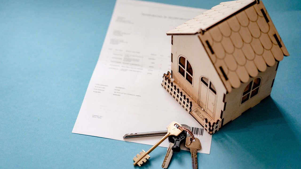 An aging parent and adult child discussing real estate paperwork and property deeds at a table.