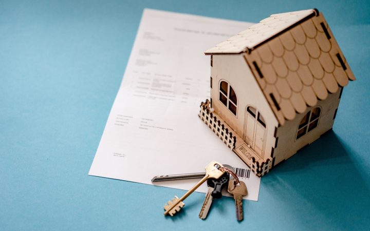 An aging parent and adult child discussing real estate paperwork and property deeds at a table.