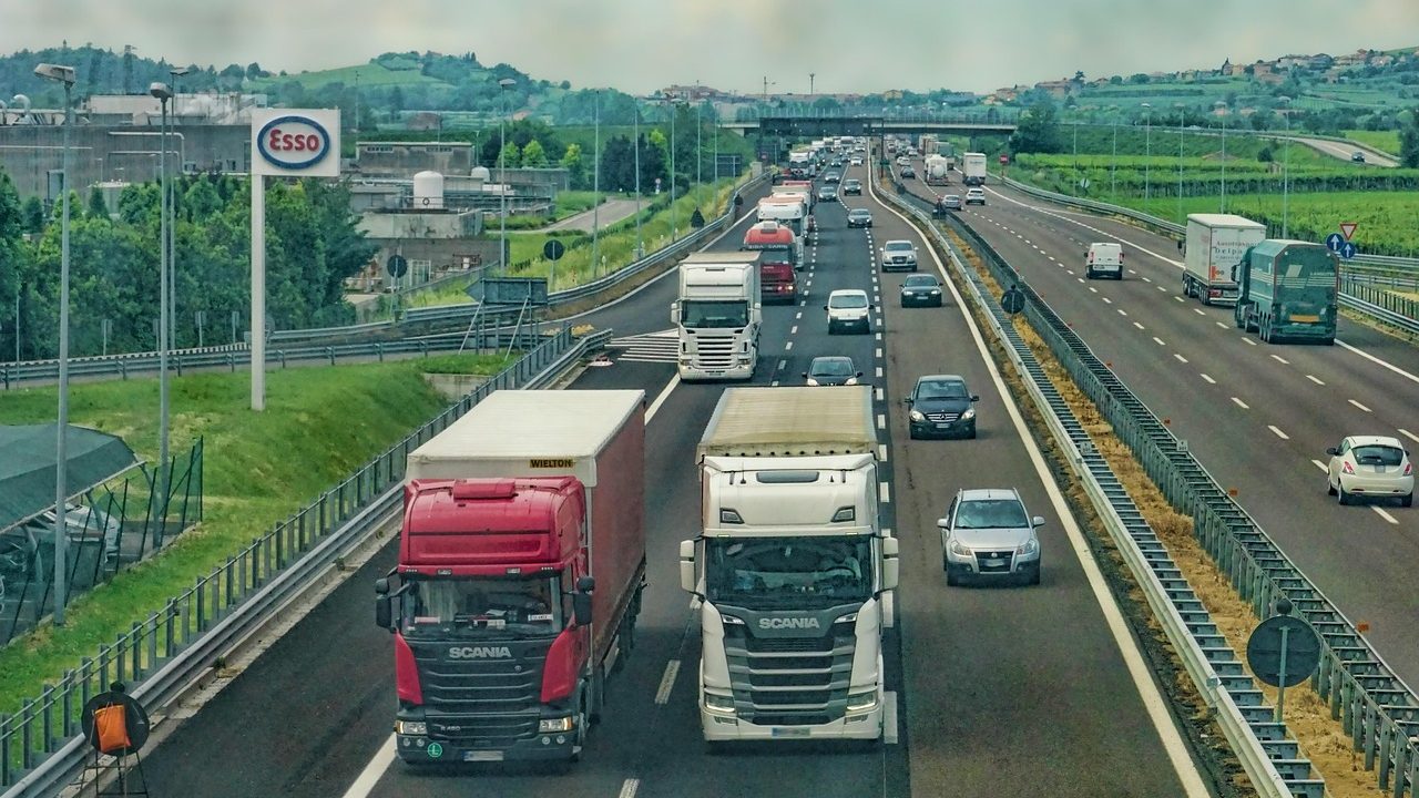 An auto transport semi-truck driving on an interstate highway during golden hour