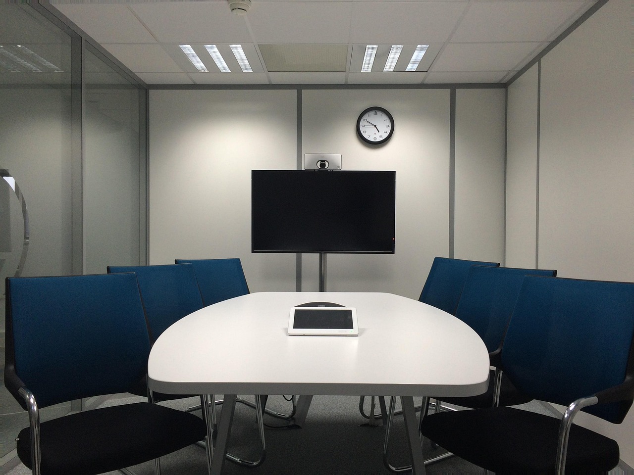 Corporate team sitting around a boardroom conference microphone during a secure executive meeting.