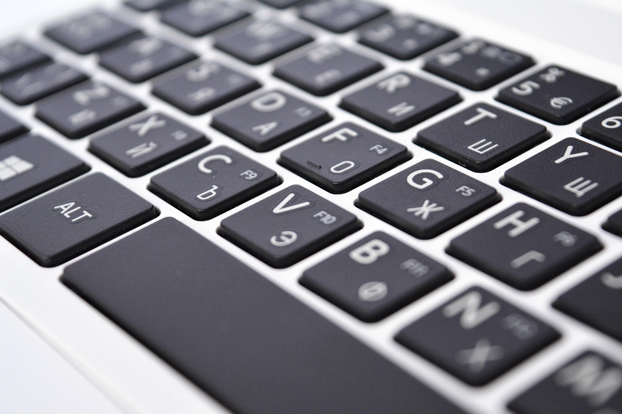 Close-up of hands typing on a laptop keyboard in a minimalist office setting