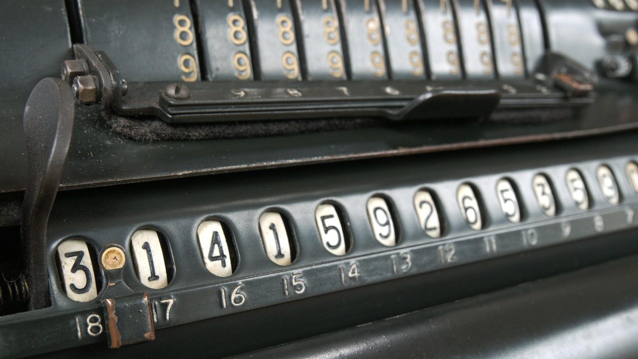 An eighth grade student reviewing math notes and a calculator at a wooden school desk.
