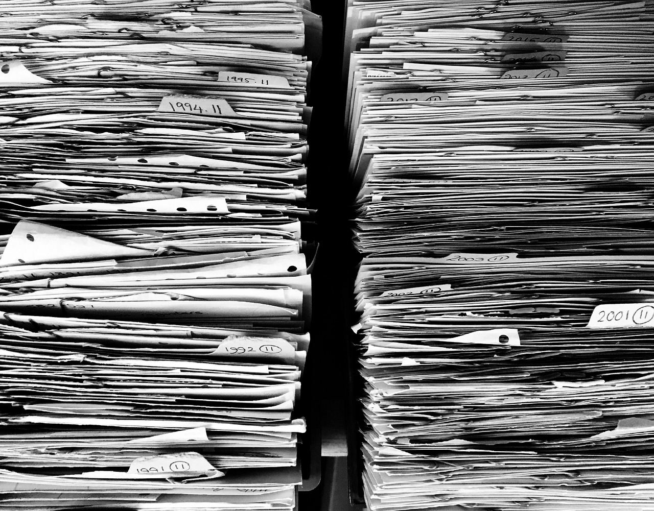 A person completing administrative appeal paperwork with supporting security system maintenance receipts laid out on a table.