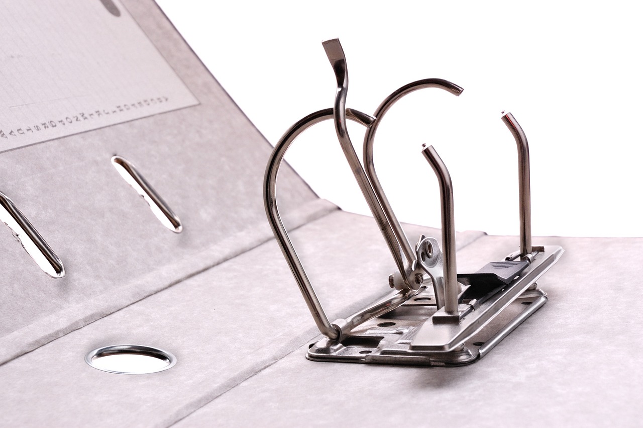 Person organizing bank statements, insurance folders, and identity cards at a table