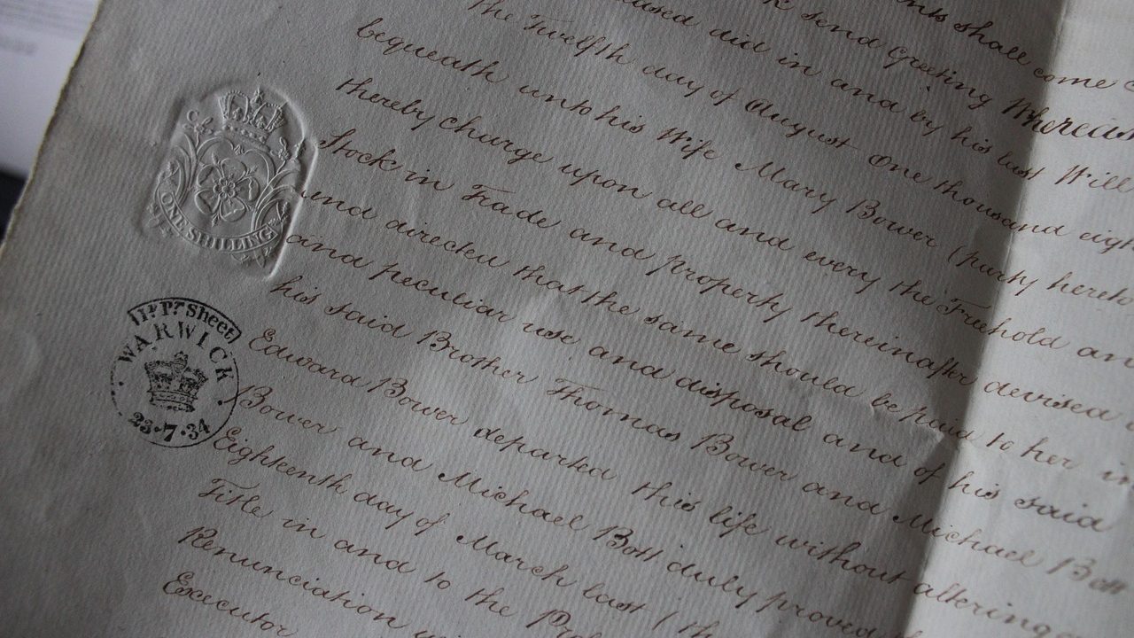 Close-up of hands signing official legal documentation at an office desk