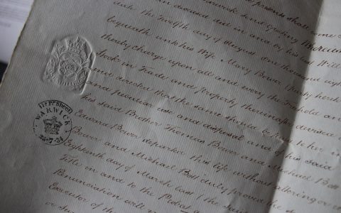 Close-up of hands signing official legal documentation at an office desk
