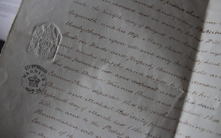 Close-up of hands signing official legal documentation at an office desk