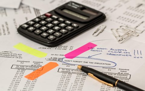 Car key and auto insurance contract documents on a office desk.