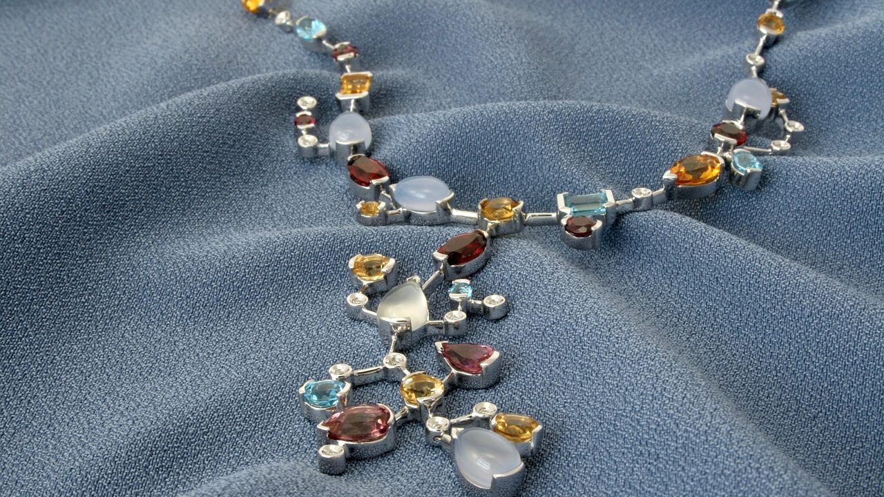 Gold estate jewelry, diamond pendant, and jeweler loupe on an evaluation desk